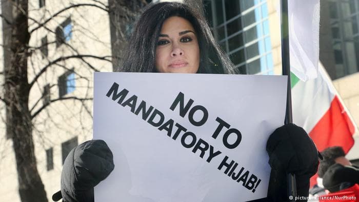 Iranian woman holding anit-hijab banner during a protest.jpg